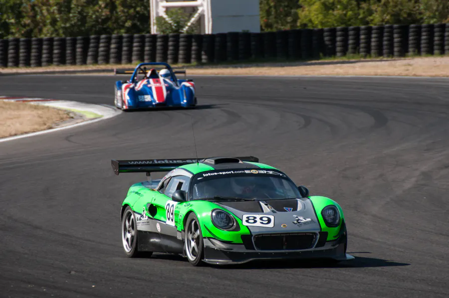 Zelený Lotus Exige se startovním číslem 89 v pravé zatáčce, za ním další vůz.